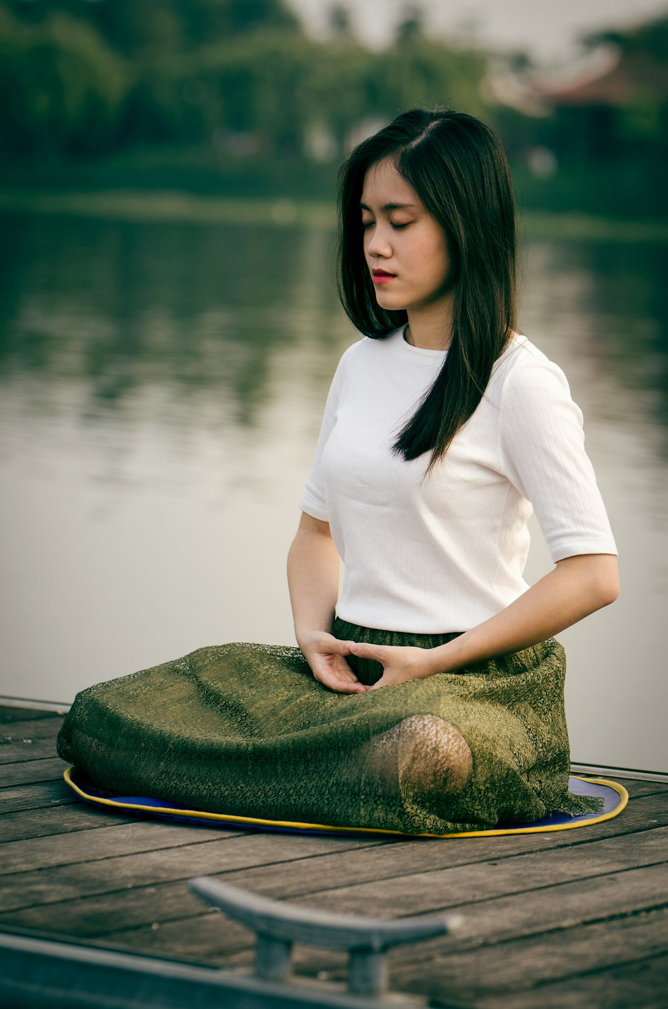 woman sitting cross legged with eyes closed meditating